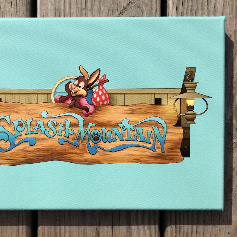 May include: A canvas print featuring the "Splash Mountain" sign with a cartoon rabbit character. The sign is made of wood with blue lettering and a paw print. The background is a light blue color.