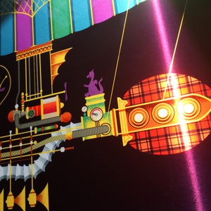 May include: A colorful, whimsical illustration of a fantastical airship or train against a black background. The design features a purple dragon, a plaid pattern, and various mechanical elements in shades of yellow, green, and orange.