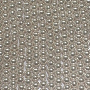 May include: A close-up image of a strand of white pearl beads. The pearls are round and smooth, and they are arranged in a uniform pattern.