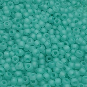 May include: A close-up view of a large quantity of small, round, opaque turquoise beads. The beads are all the same size and shape, and they are arranged in a random pattern.