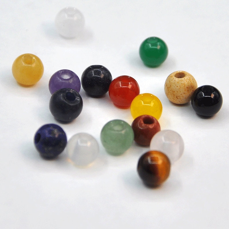 May include: Assortment of round gemstone beads in various colors, including white, yellow, purple, blue, red, green, brown, and black.