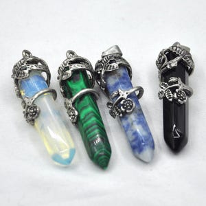 May include: Four silver pendant charms with different coloured gemstone points. The pendants feature a silver floral design and are attached to a silver chain.