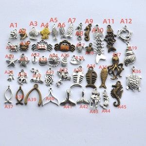 May include: A collection of 45 silver and bronze charms featuring various sea life designs, including fish, seahorses, starfish, shells, crabs, and more. The charms are labeled with letters A1 through A45.