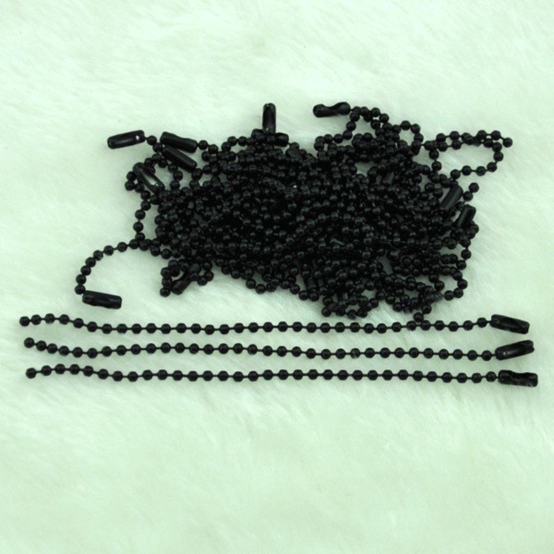 Puede incluir: Un mont&oacute;n de cadena de bolas negras con algunas cadenas dispuestas en l&iacute;nea recta. La cadena est&aacute; hecha de peque&ntilde;as bolas de metal conectadas entre s&iacute;.