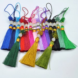 Peut inclure: Assortiment de porte-clés en soie à franges colorées avec une perle blanche et une garniture dorée. Chaque pompon mesure environ 12,7 cm de long.