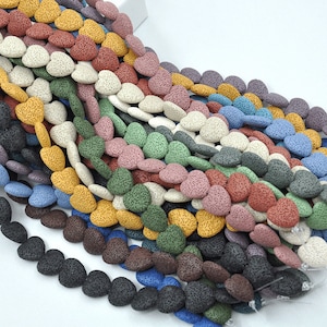 May include: A collection of heart-shaped lava rock beads in various colours, including black, brown, blue, green, yellow, and white. The beads are strung together on a wire and are ready to be used for jewellery making.