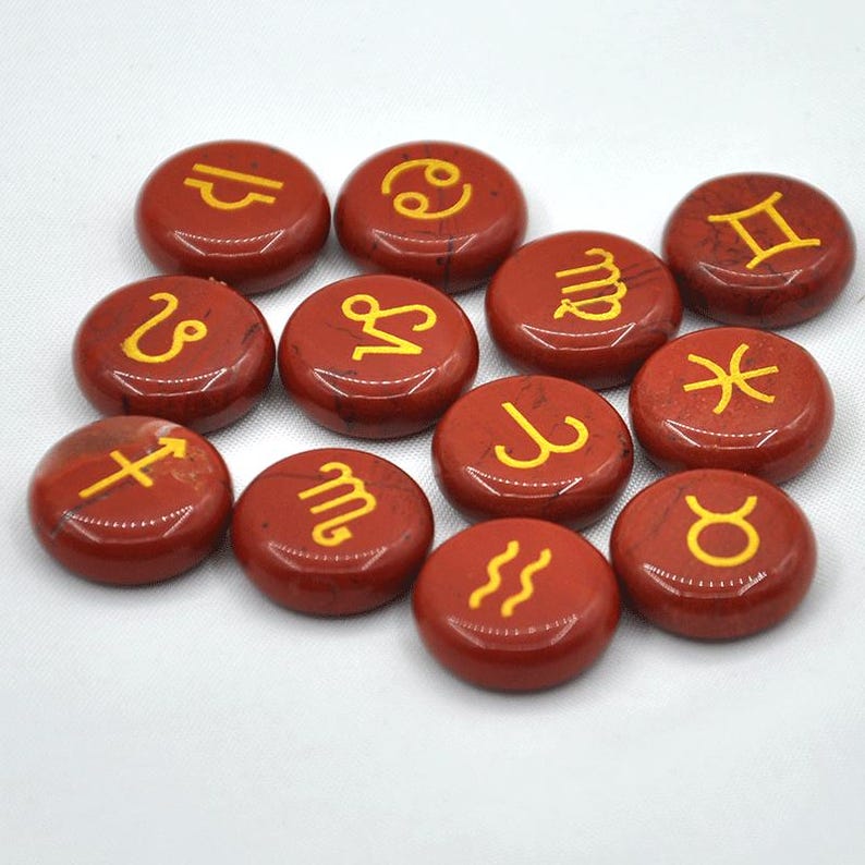 May include: Set of 12 red gemstone zodiac signs with gold symbols. The signs include Aries, Taurus, Gemini, Cancer, Leo, Virgo, Libra, Scorpio, Sagittarius, Capricorn, Aquarius, and Pisces.
