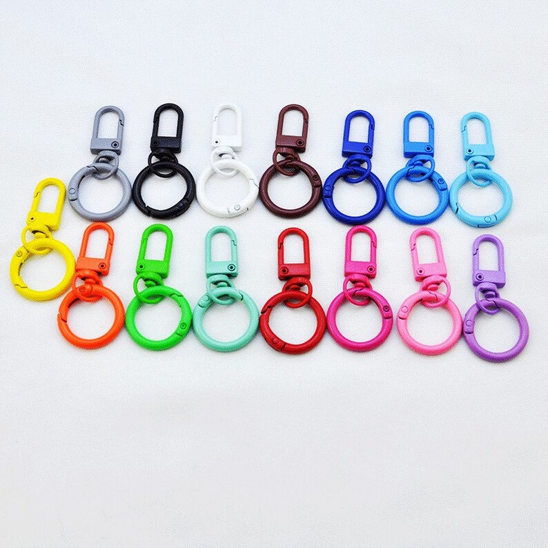 Puede incluir: Surtido de 15 llaveros met&aacute;licos de colores con cierre giratorio y un anillo redondo. Los llaveros son de varios colores, incluyendo amarillo, naranja, verde, azul, rojo, morado y blanco.