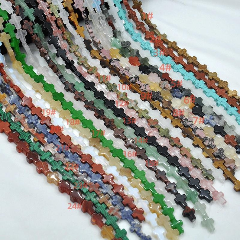 May include: A variety of gemstone cross beads in different colors and patterns. The beads are strung together on a string and are ready to be used for jewelry making.