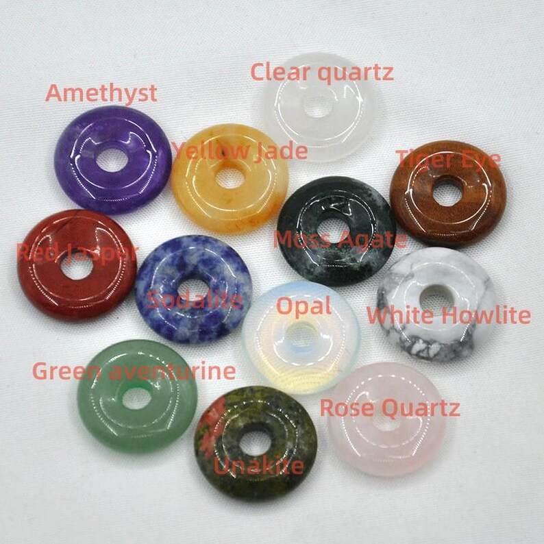Pode incluir: Conjunto de 10 pingentes de pedras preciosas em forma de rosquinha em v&aacute;rias cores, incluindo ametista, quartzo transparente, jade amarelo, olho de tigre, &aacute;gata musgosa, opala, howlite branca, aventurina verde, unakita e quartzo rosa.