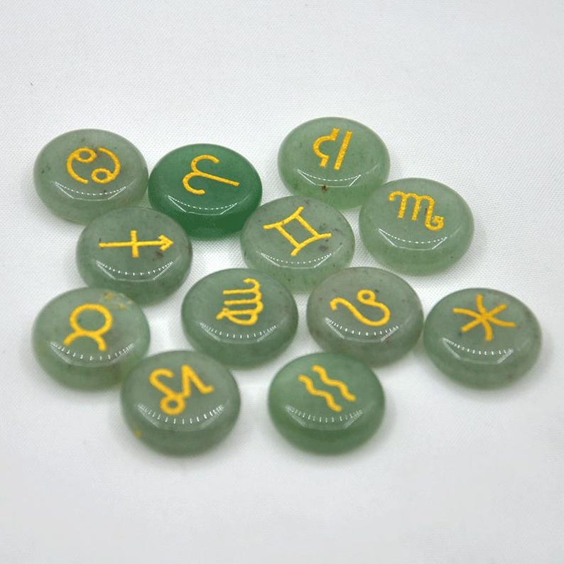May include: A set of 12 green stone zodiac signs with gold lettering. The signs are arranged in a random pattern on a white background.