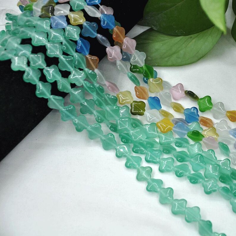 Puede incluir: Hebras de cuentas de colores en varias formas y colores. Las cuentas son en tonos de verde, azul, rosa, amarillo y naranja. Las cuentas est&aacute;n ensartadas, creando un accesorio decorativo. Las cuentas probablemente se utilizan para la fabricaci&oacute;n de joyas u otros proyectos de artesan&iacute;a.