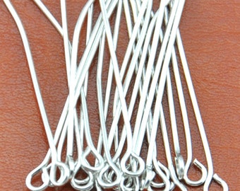 May include: A pile of silver-toned head pins with a loop at one end. The pins are about 1 inch long.