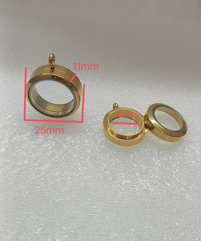 Puede incluir: Dos colgantes de medall&oacute;n de metal dorado con inserciones de vidrio transparente. El colgante m&aacute;s grande mide 25 mm de di&aacute;metro y 11 mm de alto. El colgante m&aacute;s peque&ntilde;o mide 18 mm de di&aacute;metro.