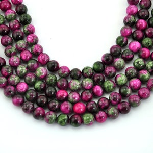 May include: A strand of pink and green gemstone beads. The beads are round and have a mottled appearance.