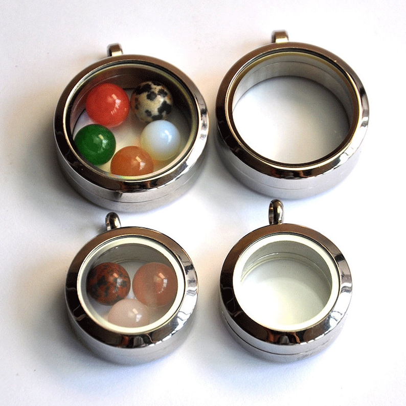 Puede incluir: Cuatro colgantes de locket plateados con ventanas de vidrio. Un locket est&aacute; lleno de cinco piedras de colores. Los otros tres lockets est&aacute;n vac&iacute;os.