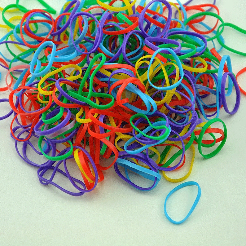 Pu&ograve; includere: Un grande mucchio di elastici colorati in rosso, blu, verde, giallo e viola.
