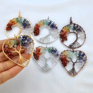 May include: Five wire wrapped tree of life pendants with different colored gemstones. The pendants are in the shapes of a circle and a heart. The gemstones are red, orange, yellow, green, blue, and purple.