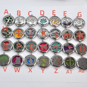 May include: A set of 26 silver-toned metal aromatherapy diffusers with various designs, including a four-leaf clover, a tree, a butterfly, a dragonfly, and a musical note. Each diffuser has a small hole for adding essential oils.