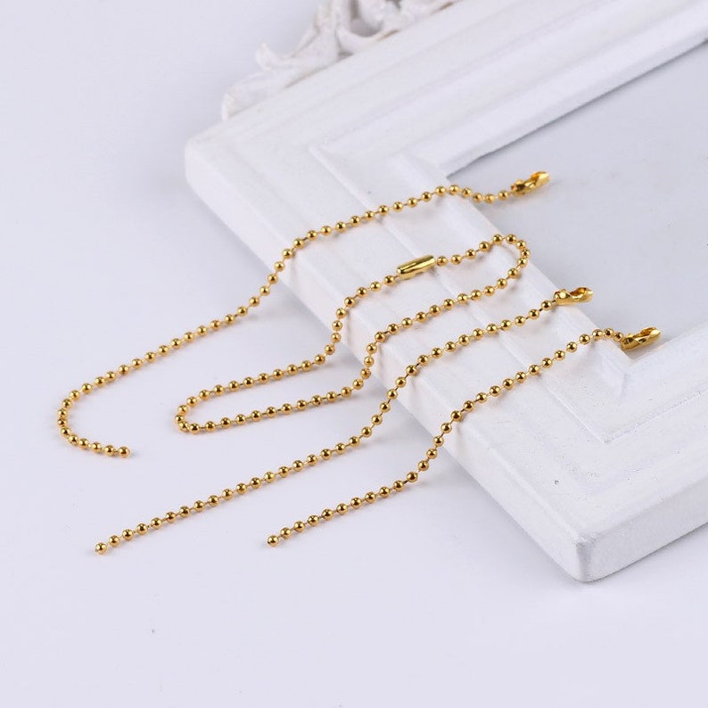 Puede incluir: Cuatro collares de cadena de bolas doradas de diferentes longitudes. Las cadenas est&aacute;n hechas de peque&ntilde;as cuentas redondas.