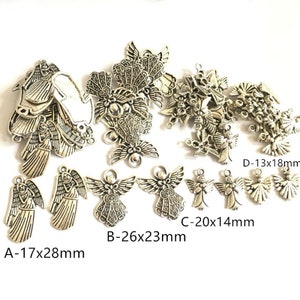 Può includere: Una collezione di ciondoli a forma di angelo in argento di varie dimensioni. I ciondoli sono dettagliati con disegni intricati e hanno un aspetto vintage. I ciondoli sono etichettati con le loro dimensioni in millimetri: A-17x28mm, B-26x23mm, C-20x14mm, D-13x18mm.