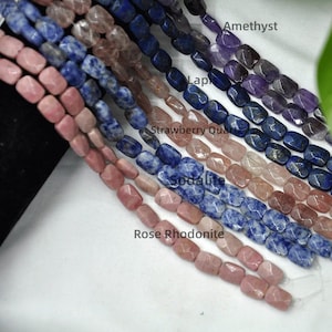 Puede incluir: Primer plano de varios hilos de cuentas de piedras preciosas en varios colores. Las cuentas incluyen Rodonita Rosa, Sodalita, Cuarzo Fresa, Lapislázuli y Amatista. Las cuentas son rectangulares y facetadas.