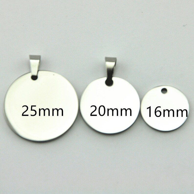 May include: Three silver metal round blank tags with jump rings. The tags are 25mm, 20mm, and 16mm in diameter.