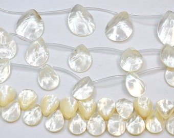 May include: A strand of white mother of pearl teardrop shaped beads. The beads are strung on a clear elastic cord.