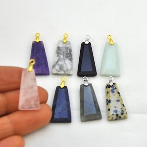 Peut inclure: Huit pendentifs en pierres précieuses avec des anneaux de saut en or et en argent. Les pierres précieuses sont l'améthyste, le marbre blanc, l'onyx noir, l'aventurine verte, le quartz rose, le lapis-lazuli, le labradorite et le jaspe dalmatien.