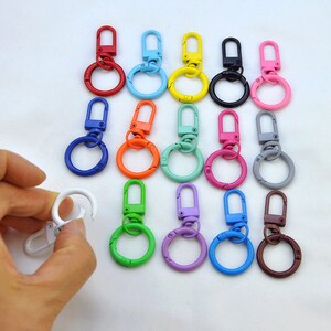 Puede incluir: Surtido de 14 llaveros met&aacute;licos de colores con cierre giratorio y un anillo redondo. Los llaveros son de varios colores, incluyendo rojo, azul, verde, amarillo, rosa, naranja, morado y gris.