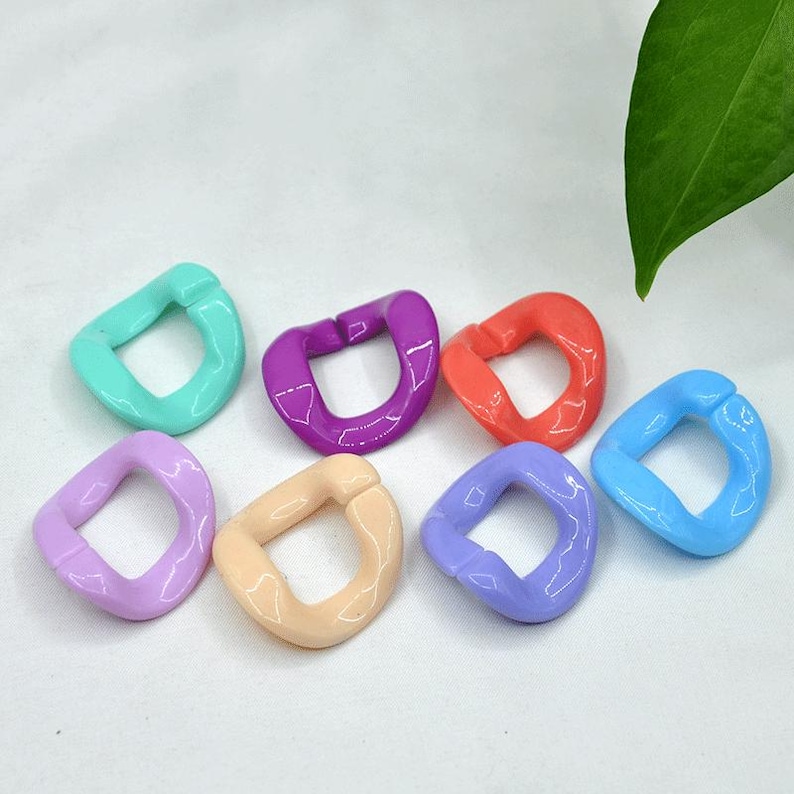 Puede incluir: Siete anillos de pl&aacute;stico coloridos en varios tonos de azul, morado, rosa, naranja y verde. Los anillos son todos del mismo tama&ntilde;o y forma, con un dise&ntilde;o redondeado ligeramente curvado.