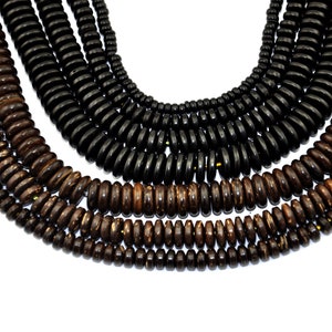 May include: A set of wooden beads in two shades of brown. The beads are round and have a slightly textured surface. The beads are arranged in a circular pattern, with the darker brown beads on the outside and the lighter brown beads on the inside.