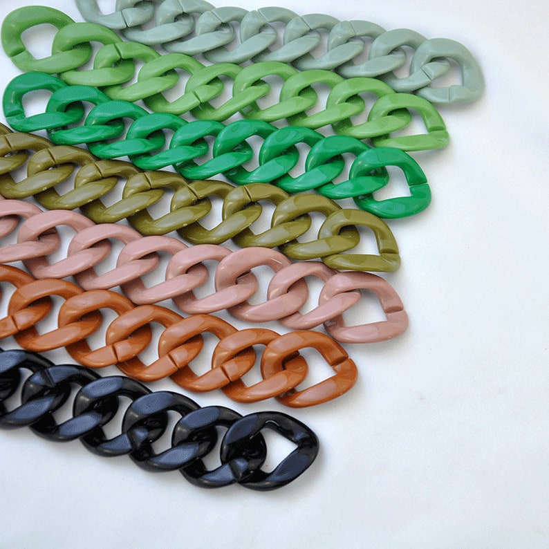 Puede incluir: Un conjunto de cadenas de pl&aacute;stico de colores en varios tonos de verde, marr&oacute;n, rosa y negro. Las cadenas est&aacute;n dispuestas en forma de abanico, con el color m&aacute;s claro en la parte superior y el color m&aacute;s oscuro en la parte inferior.
