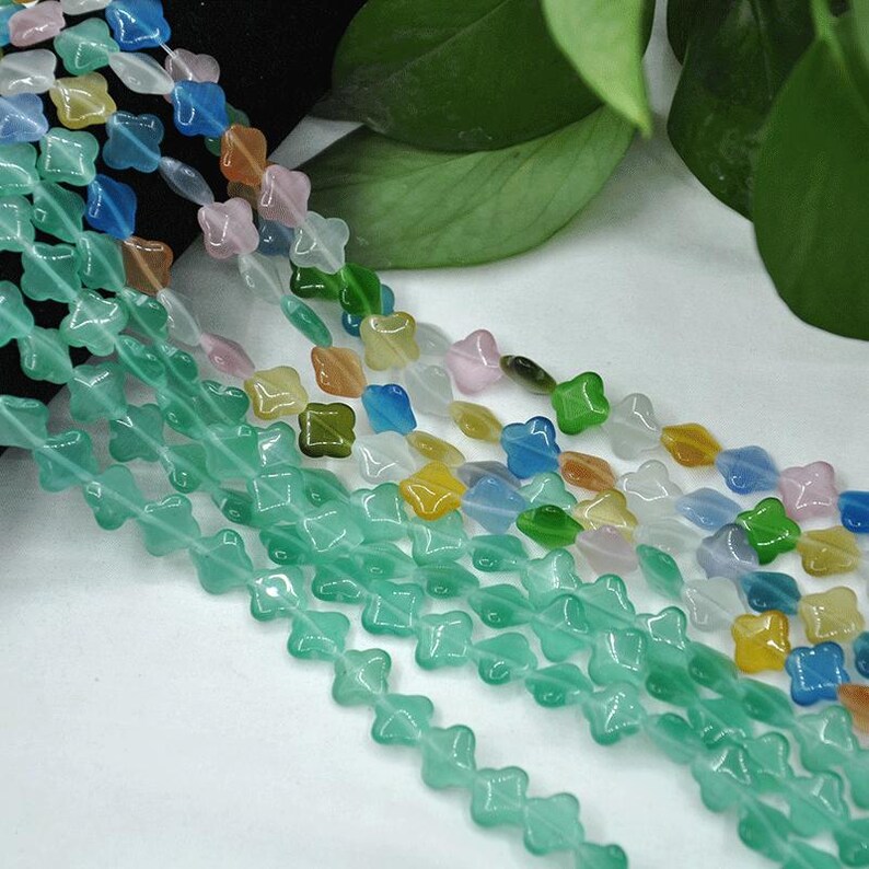 Puede incluir: Hebras de cuentas de colores en varias formas y colores, incluyendo verde, azul, amarillo, rosa y naranja. Las cuentas est&aacute;n ensartadas, creando un elemento decorativo. Las cuentas son probablemente para la fabricaci&oacute;n de joyas o manualidades.