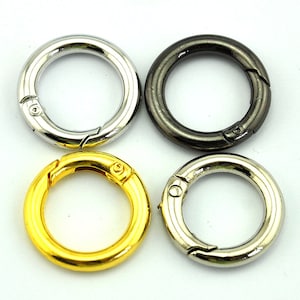 Puede incluir: Cuatro llaveros de metal en diferentes colores: plateado, negro, dorado y cromado. Cada anillo tiene un cierre de resorte.