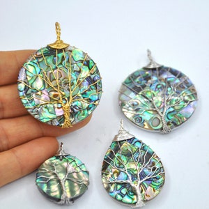 May include: Four iridescent abalone shell pendants with wire wrapped tree of life designs. The pendants are in various shapes and sizes, including round and teardrop. The wire is gold and silver.