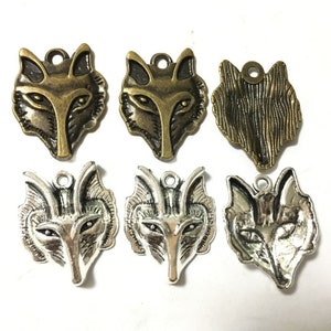 May include: Six metal wolf head charms, three in antique gold and three in silver. The charms have a detailed design and a loop for attaching to jewelry or other crafts.