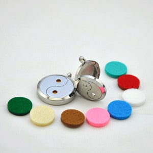 May include: Two silver yin yang essential oil diffusers with a variety of felt pads in different colors, including green, white, brown, pink, blue, red, and turquoise.