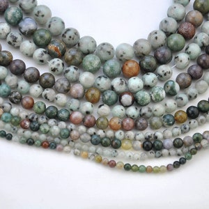 Puede incluir: Una hebra de cuentas de piedra preciosa moteadas de verde, marr&oacute;n y blanco. Las cuentas son redondas y tienen un acabado liso y pulido.
