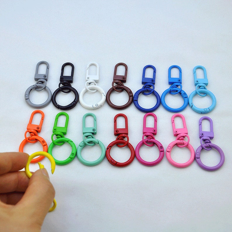 Puede incluir: Surtido de 14 llaveros met&aacute;licos de colores con cierre giratorio y un anillo redondo. Los llaveros son de varios colores, incluyendo amarillo, verde, azul, rojo, rosa, morado, blanco, negro y gris.