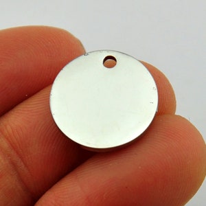 May include: A round, silver-colored metal tag with a hole at the top. The tag is blank and ready to be engraved.