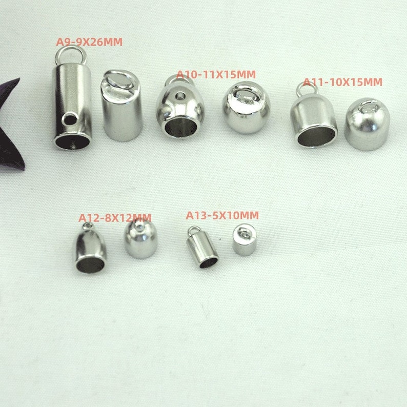 May include: Assortment of silver metal end caps for cords or jewelry making. The caps are in various sizes and shapes, including round, cylindrical, and bell-shaped. The sizes are labeled with the text A9-9X26MM, A10-11X15MM, A11-10X15MM, A12-8X12MM, and A13-5X10MM.