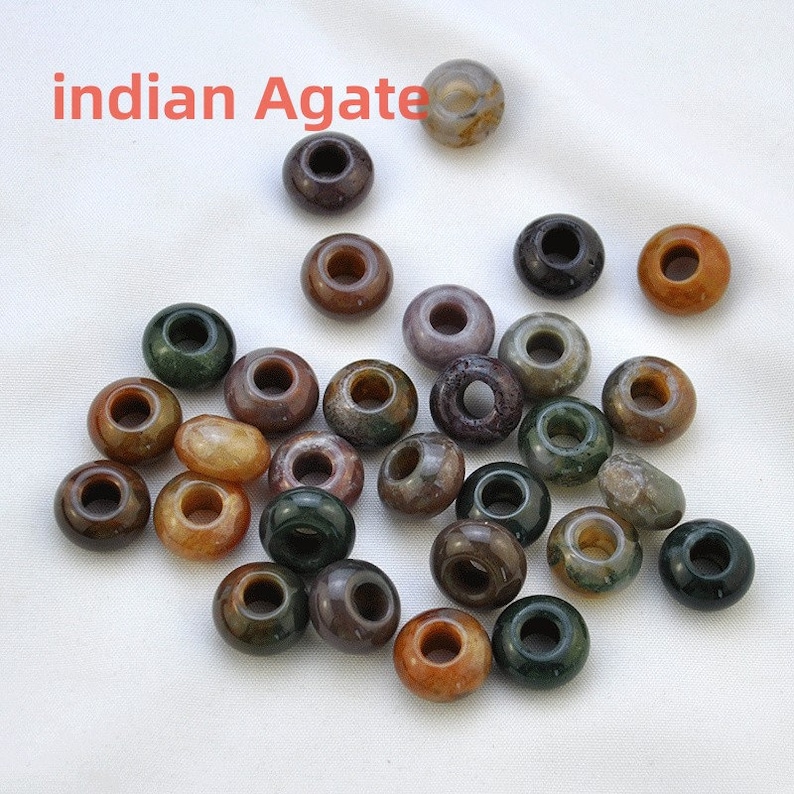 May include: A collection of 25 assorted Indian agate beads. The beads are round with a hole in the center and are various shades of brown, green, and white.