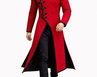 May include: A long, red quilted coat with black trim and decorative black clasps. The coat features a high collar and a split front, creating a dramatic silhouette. The coat is paired with black pants and brown boots.