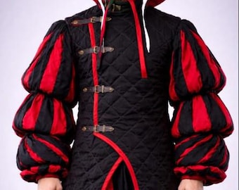 May include: A black quilted doublet featuring a high collar, red trim, and three brown leather buckled straps across the front. The garment has voluminous sleeves with alternating black and red vertical stripes and a large red hat with white ties.