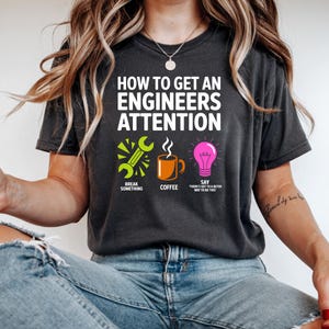 T-shirt with "How to Get an Engineer's Attention" and icons for breaking something, coffee, and a lightbulb with text.