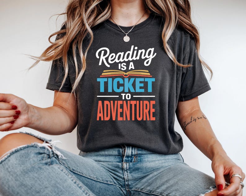 Woman wearing dark t-shirt with "Reading is a Ticket to Adventure" text.