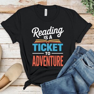 Black t-shirt with "Reading is a ticket to adventure" text.