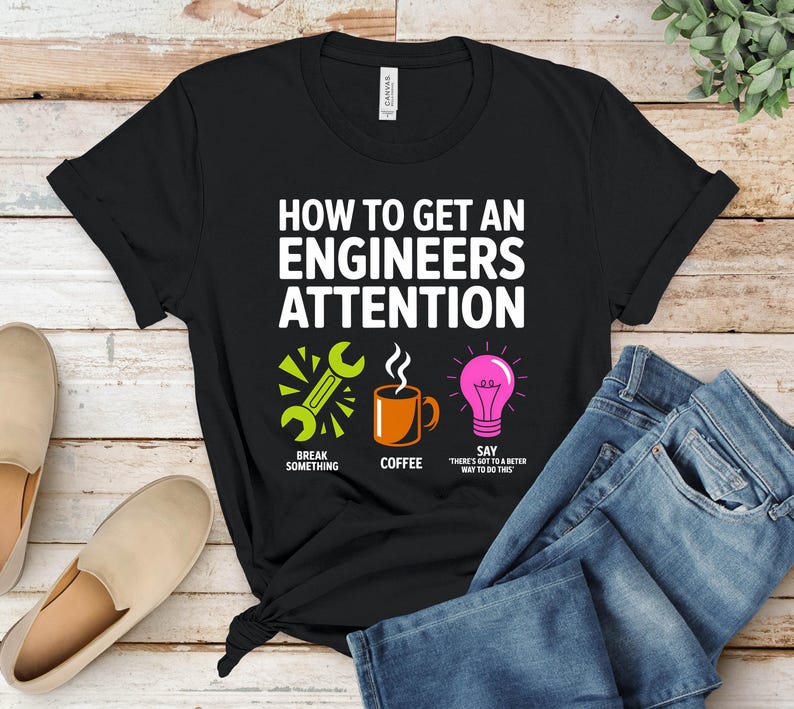 Black t-shirt with "How to Get an Engineer's Attention" and three icons.