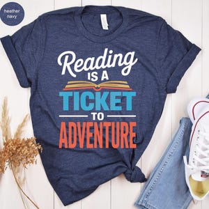 Navy t-shirt with "Reading is a ticket to adventure" text and book graphic.